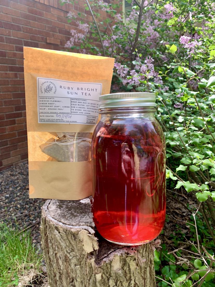 Brewed Ruby Sun Tea next to a package of tea bags